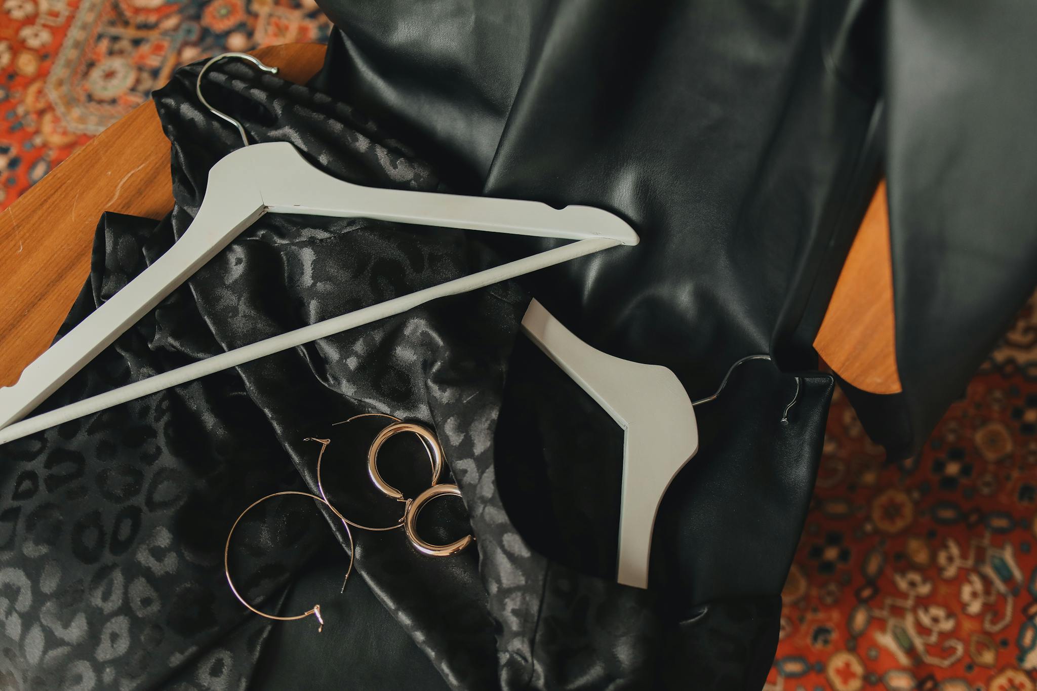 Elegant fashion arrangement with a black dress, metallic earrings, and more, perfect for chic styling.