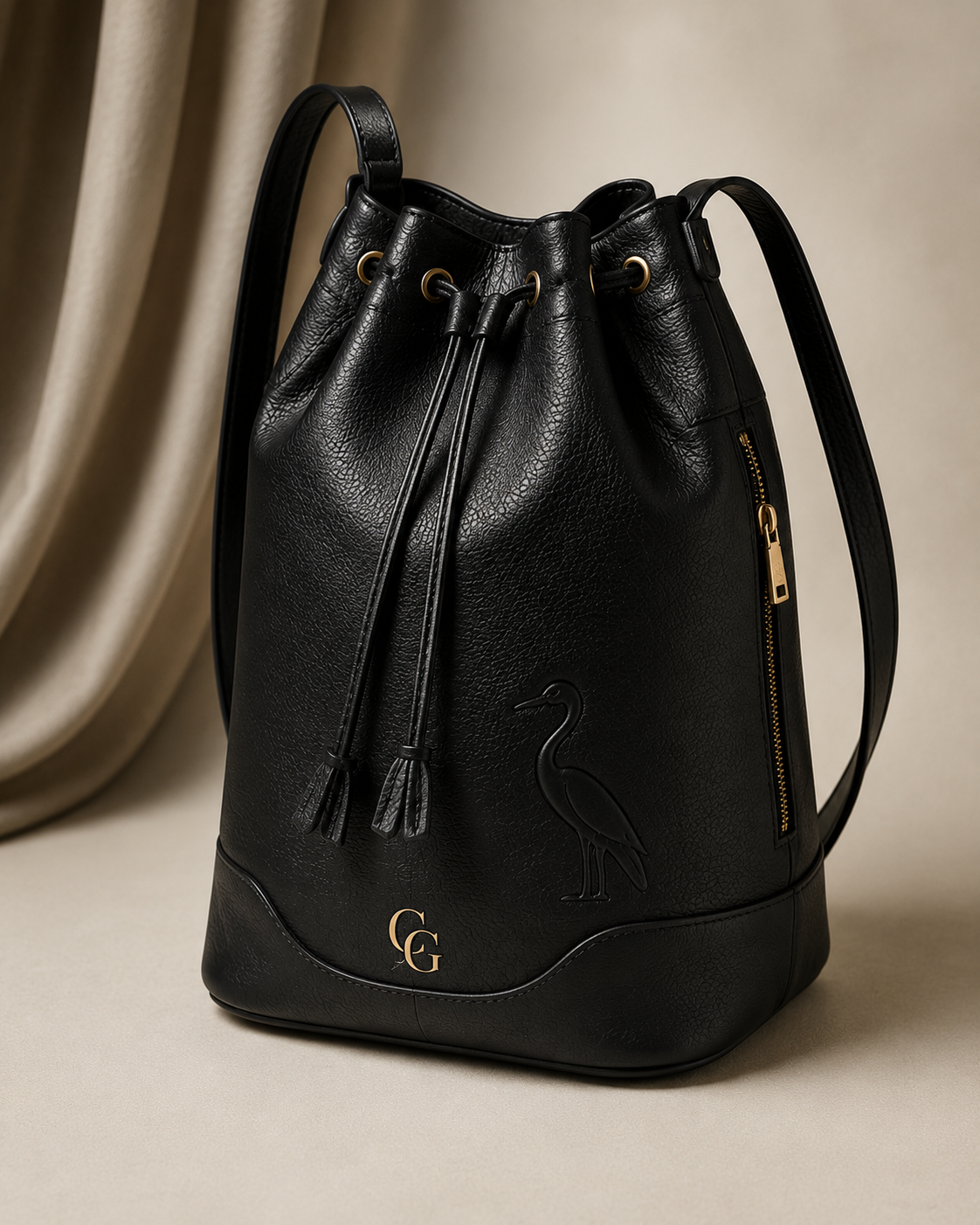 Tula Peregrina CG luxury black leather bucket bag with subtle gold logo and embossed heron detail.
