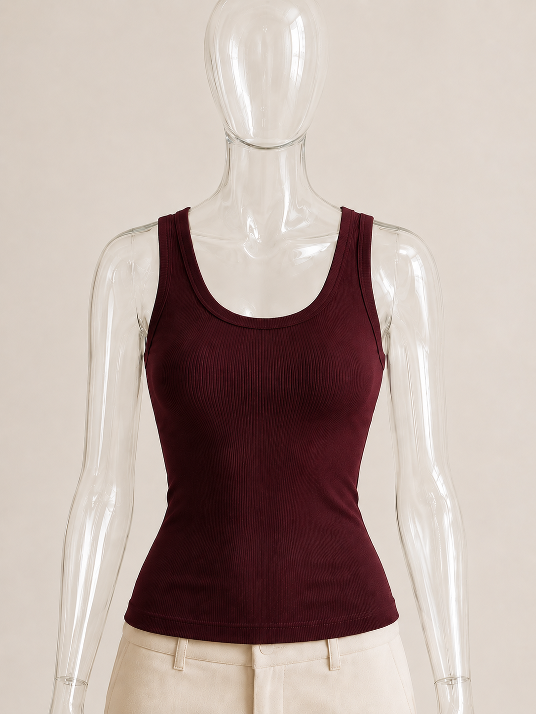 Burgundy rib tank top by CG Claudia Garcia displayed on a transparent glass mannequin against a soft beige background.