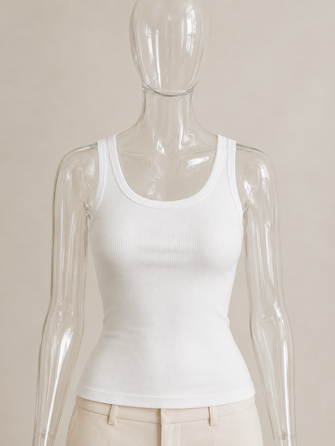 White rib tank top by CG Claudia Garcia is displayed on a transparent glass mannequin against a soft beige background.